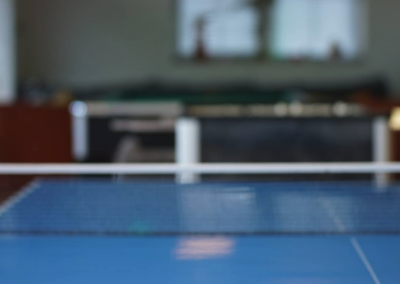 Tischtennisschläger und Ball liegen auf einer blauen Tischtennis-Platte