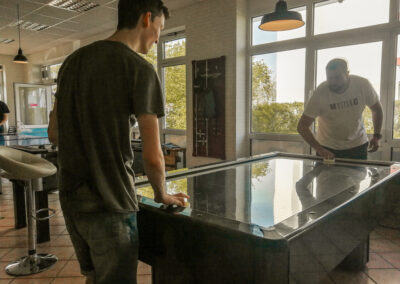 Ein Jugendlicher und ein Mann spielen Airhockey