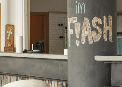 Mit bunter Kreide beschriebene Säule und Bar mit Barhocker